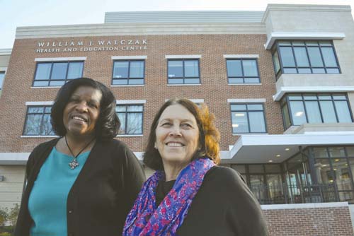 Codman's latest addition: Sandra Cotterell, CEO of the Codman Square Health Center, left and Meg Campbell, executive director of the Codman Academy Charter Public School, outside the newly-opened William J. Walczak Education and Health Center on Epping Street. 